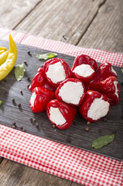 Yumuşak peynir Beyaz ahşap rustik arka plana sahip siyah koyu plaka üzerinde meze meze tatlı kiraz kırmızı ve yeşil kiraz biber dolması. 