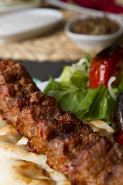 Türkçe ve Arapça geleneksel Adana Kebap sunumu salata ile bakış plaka üzerinde kapatın