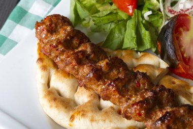 Türkçe ve Arapça geleneksel Adana Kebap sunumu salata ile bakış plaka üzerinde kapatın