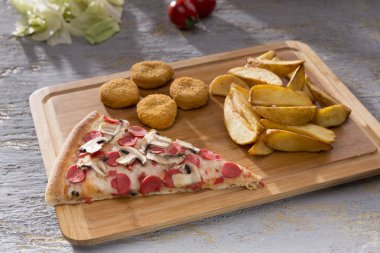 patates kızartması ve tavuk nuggets ahşap kesme tahtası üzerinde hizmet İtalyan pizza görünümünü kapat