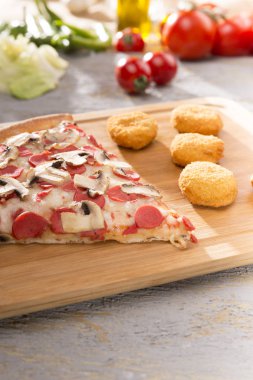 İtalyan pizza ve kızarmış tavuk nuggets ahşap kesme tahtası üzerinde hizmet görünümünü kapat