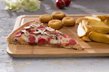 patates kızartması ve tavuk nuggets ahşap kesme tahtası üzerinde hizmet İtalyan pizza görünümünü kapat