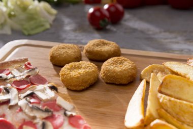 patates kızartması ve tavuk nuggets ahşap kesme tahtası üzerinde hizmet İtalyan pizza görünümünü kapat