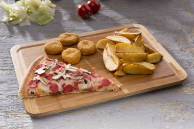 patates kızartması ve tavuk nuggets ahşap kesme tahtası üzerinde hizmet İtalyan pizza görünümünü kapat