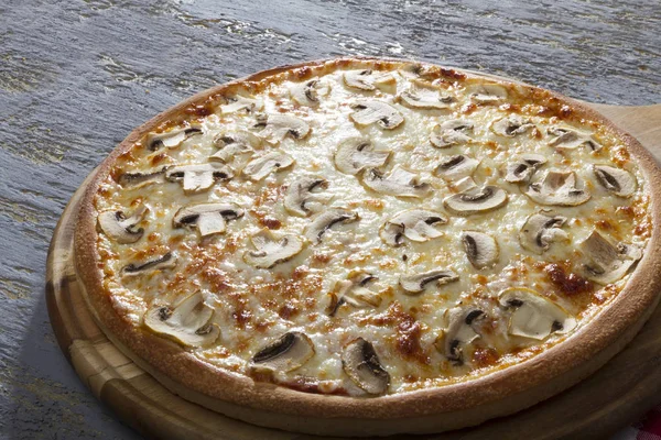 close up view of delicious pizza with mushrooms served on wooden board