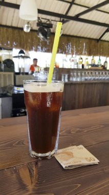 ahşap masa üzerinde soğuk kokteyl ve nakit görünümü kadar kapatın