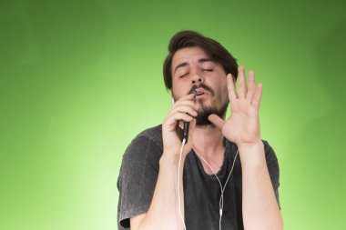 adam akıllı telefon dinleme müzik yeşil arka plan üzerinde kulaklık