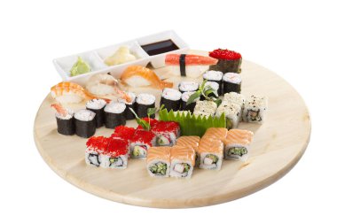 Beyaz arka plan üzerinde izole plaka üzerinde çeşitli suşi ve soya sosu görünümü kadar kapatın