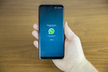 Izmir, Türkiye - 27 Haziran 2017: kısmi smartphone ahşap zemin üzerinde tutan adam görünümünü