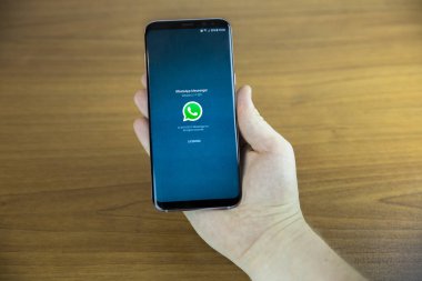 Izmir, Türkiye - 27 Haziran 2017: kısmi smartphone ahşap zemin üzerinde tutan adam görünümünü