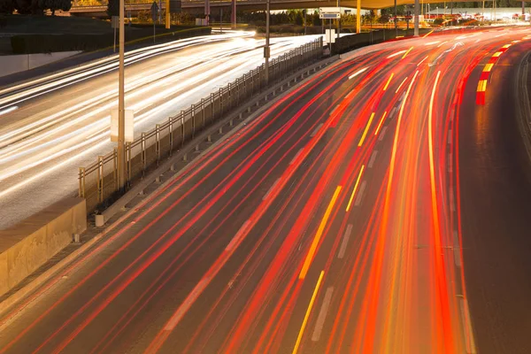Light trails on motorway highway at night, long exposure abstract urban background