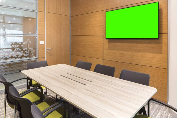 empty small meeting room with blank green TV screen