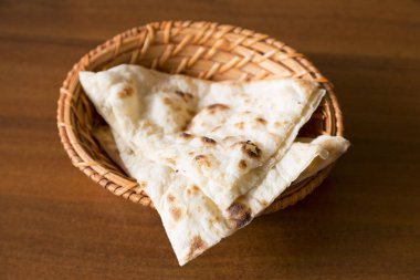 ahşap masa üzerinde sepetin içinde ekmek parçaları görünümü kadar kapatın