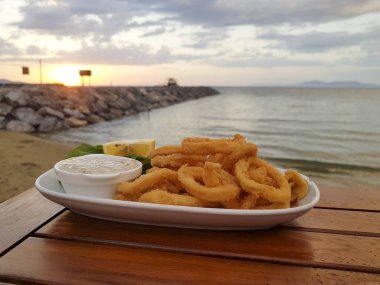 Deniz arka plan üzerinde plaka üzerinde pişmiş yemeğin görünümü kadar kapatın