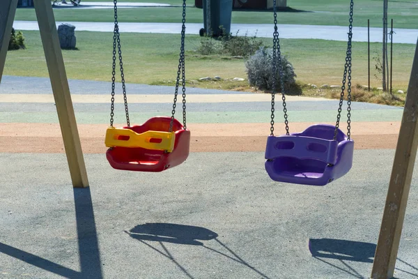 公園での子供の遊び場のカラフルなプラスチックの幼稚なスイングのビューをクローズ アップ — ストック写真