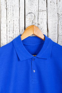 şık mavi gömlek görünümü askı üzerinde ahşap duvar arka plan üzerinde kadar kapatın