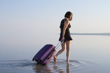 Sahil kenarında yürüyen Bagaj ile genç kadın