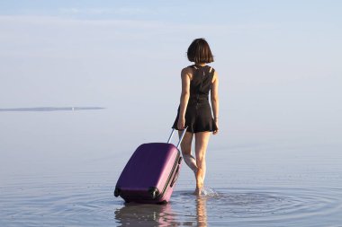 arkadan görünüşü kadın denizde yürüyen Bagaj ile