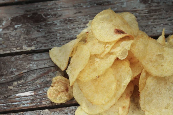 close up view of fried chips on wooden tabletop