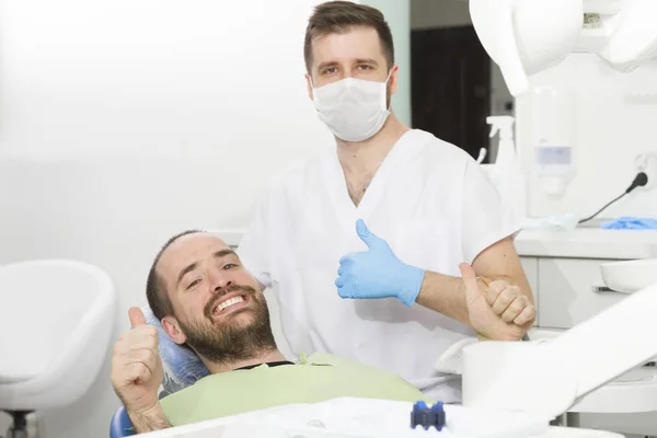 Dental klinikte genç dişçi ve mutlu hasta