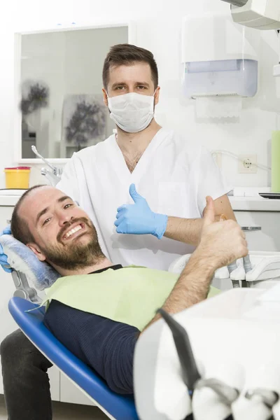 Dental klinikte genç dişçi ve mutlu hasta