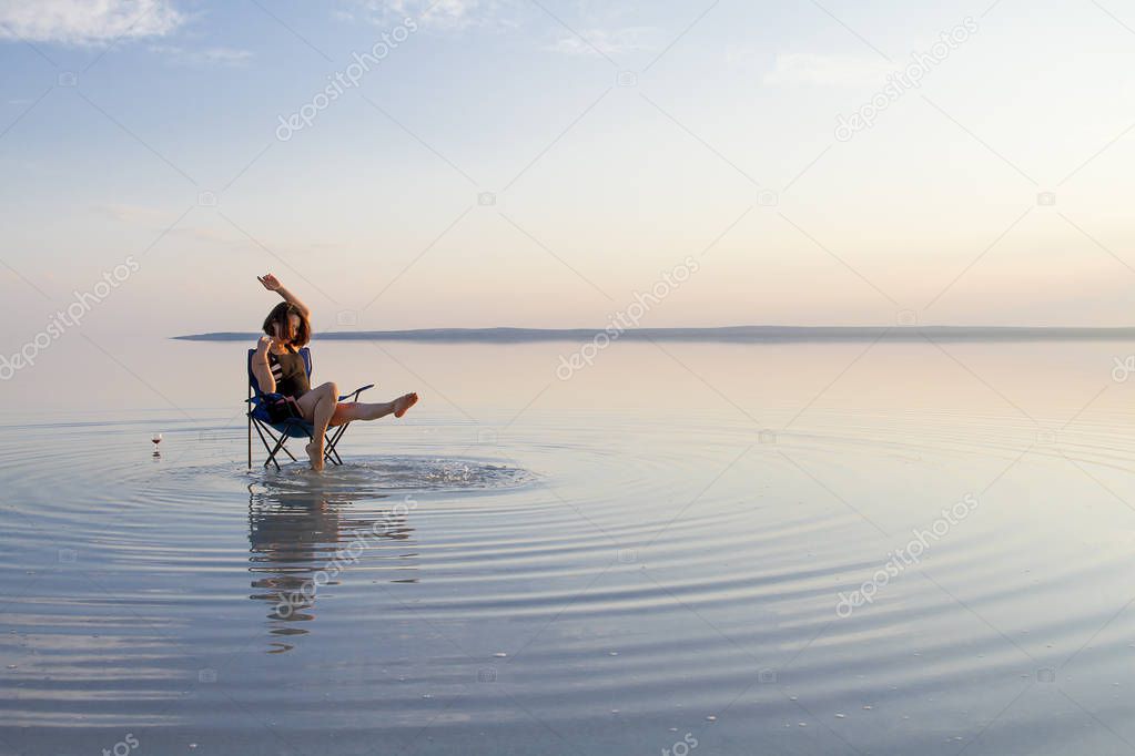 woman resting in chair at seashore during sunset