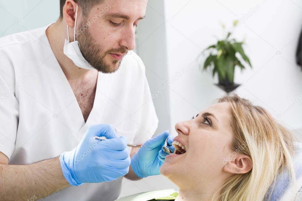 male dentist and young female patient during procedure in dental clinic