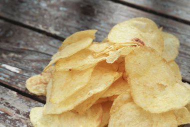 ahşap masa üzerinde kızarmış cips görünümü kadar kapatın