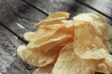 ahşap masa üzerinde kızarmış cips görünümü kadar kapatın