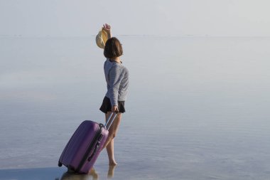 Sahil kenarında yürüyen Bagaj ile genç kadın