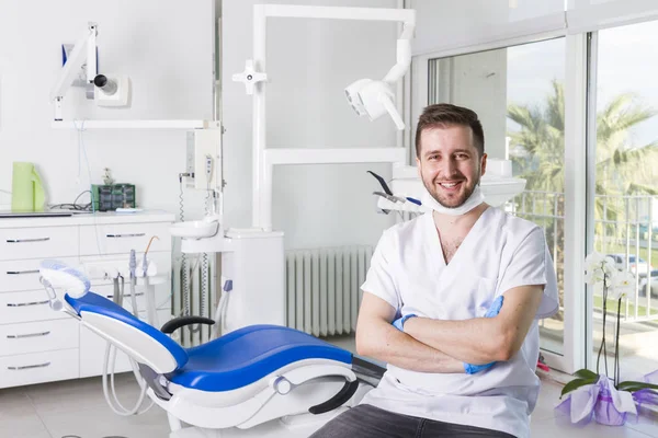 young male dentist in uniform in dental clinic