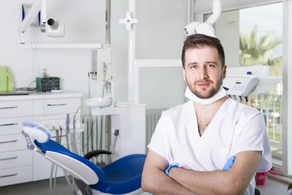 young male dentist in uniform in dental clinic