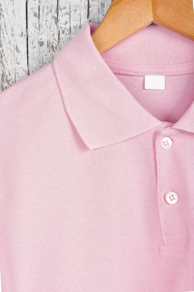close up view of stylish pink shirt on hanger on wooden wall background