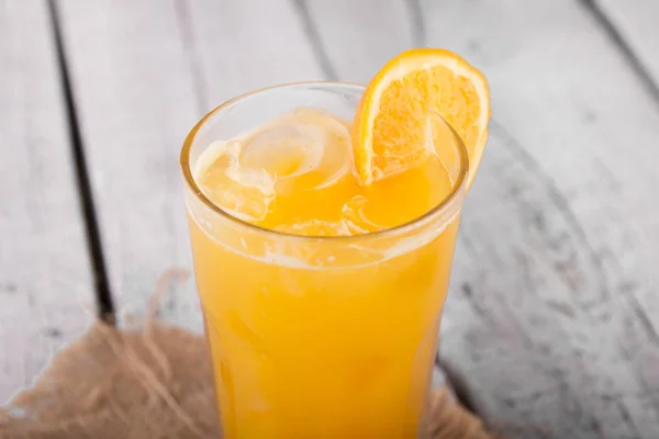 refreshing orange juice with ice in glass