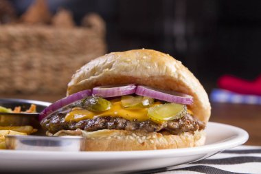 pişmiş burger sos ve patates kızartması ile tabakta servis