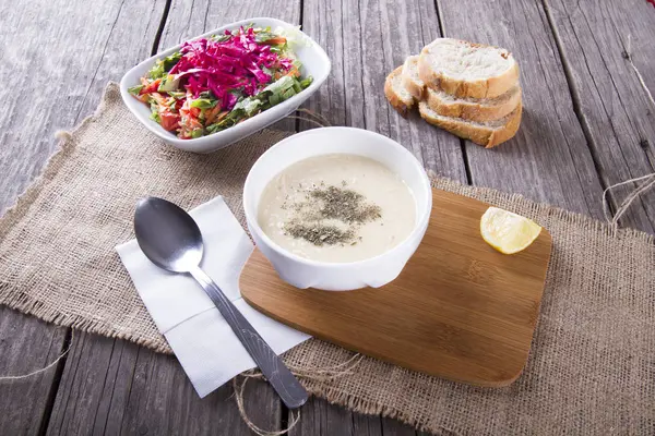 close up view of homemade soup and salad on wooden tabletop