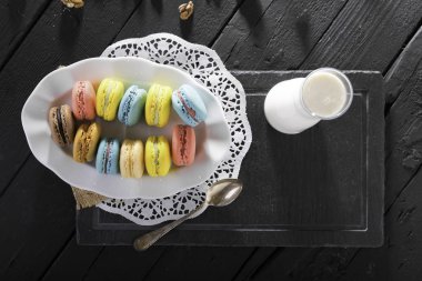 ahşap masa üzerinde süt ile tatlı renkli makarna ve cam sürahi üst görünümü