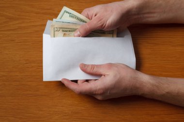 Aç gözlü tüylü adamın elleri devraldı bazı rüşvet bizi dolar banknotlar boş beyaz zarfın içinde ahşap bir meşe masa ofis