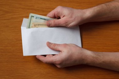 Aç gözlü tüylü adamın elleri devraldı bazı rüşvet bizi dolar banknotlar boş beyaz zarfın içinde ahşap bir meşe masa ofis