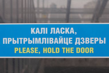 Lütfen, kapı mavi tabelayı Minsk şehrinde uluslararası turistler için İngilizce ve Rusça dil tutun