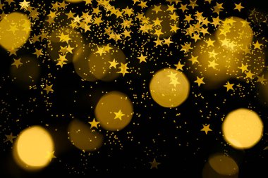 gold glitter, star confetti and bokeh lights on a black background