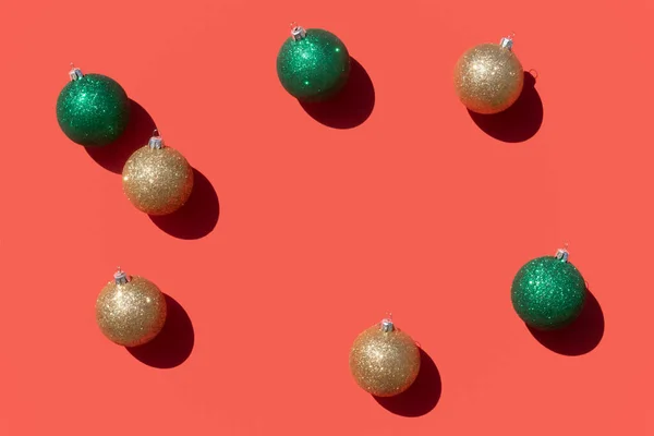 Oro e verde ornamenti di Natale modello su uno sfondo rosso corallo — Foto Stock