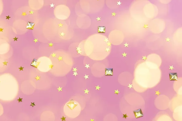 Pedras preciosas de ouro e estrela confetti em um fundo rosa pastel — Fotografia de Stock