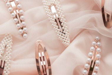 Pembe tül arka planda inci desenli saç tokaları.