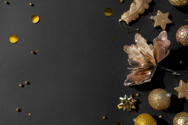 Luxe gouden kerst platte lay van verschillende ornamenten op een zwarte achtergrond — Stockfoto