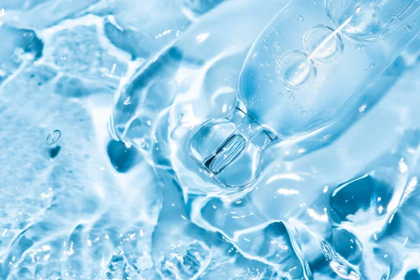 Sıvı ile pipette makrosu ve mavi arkaplan üzerine damla