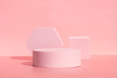 Geometrik şekilli mercan pembe podyumu. Arka plan tek renkli.