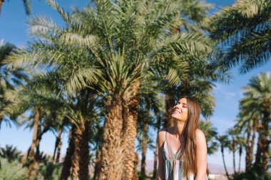 Tatil tropikal plaj yaz tatil palmiye ağaçları ve tarihi avuç içi ile kameraya gülümseyen kadın