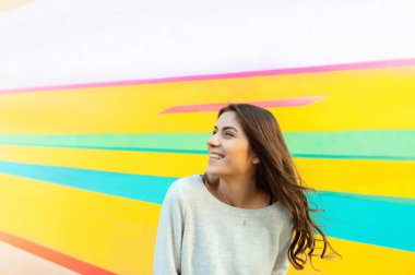 Genç güzel beyaz kadın kenti yakınlarındaki bir renkli duvar açık poz