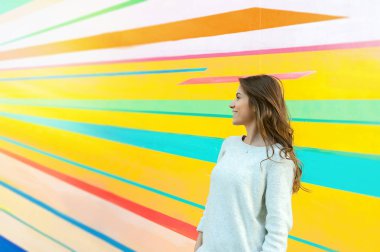 Genç güzel beyaz kadın kenti yakınlarındaki bir renkli duvar açık poz